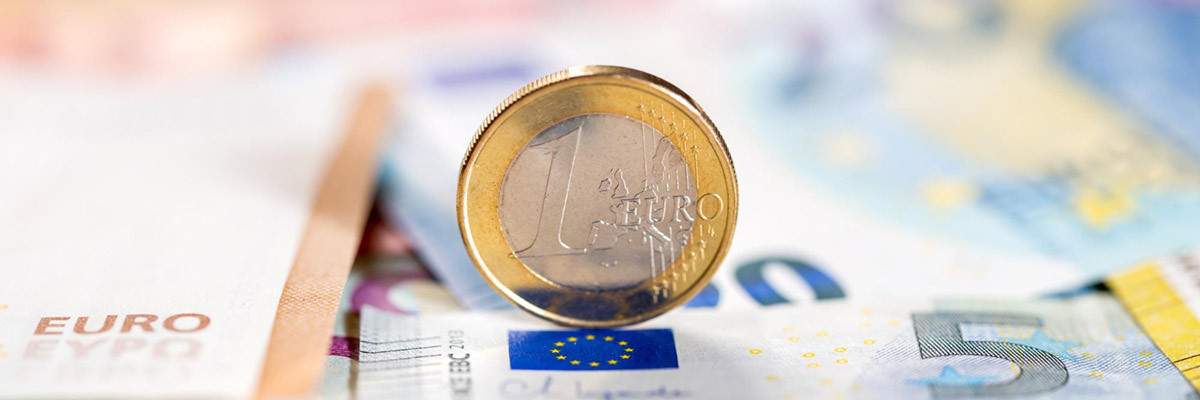 Zinsbindung kann bares Geld bedeuten - Euromünze auf Geldscheinen